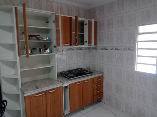a kitchen with wooden cabinets and a stove at Casa Freire in Lavras