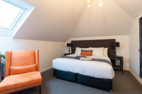 - une chambre avec un lit et une chaise orange dans l'établissement Annie May- Devonport, à Devonport