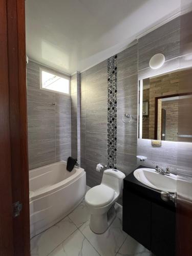 ein Badezimmer mit Badewanne, Toilette und Waschbecken in der Unterkunft The Cayetano House in Cali