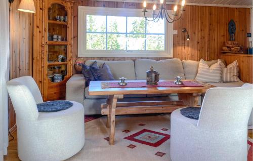 ein Wohnzimmer mit einer Couch und einem Tisch und Stühlen in der Unterkunft Cozy Home In Sjusjøen in Sjusjøen