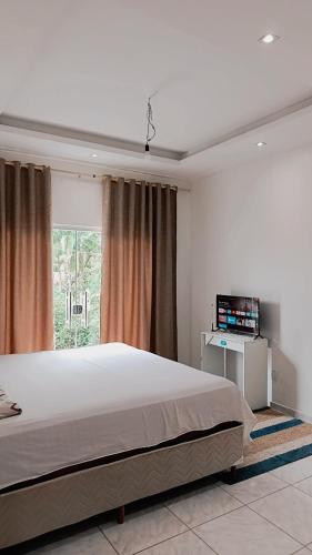 a bedroom with a large bed and a window at Família Freitas in Ananindeua
