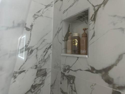 a bathroom with a shelf with bottles on it at peace in Fort Myers