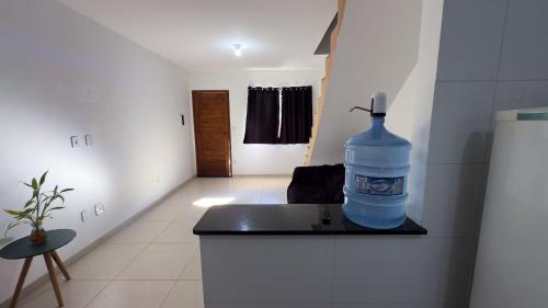 a large blue water bottle sitting on a counter in a kitchen at Duplex em Itaúna 4min da Praia que ocorre o WSL, 1min da pista de skate do LS, pracinha com parque infantil, quadra de futebol, tudo isso a 1 min da duplex, perto do comércio, wi-fi super rápido, estacionamento gratuito, monitoramento 24hrs in Saquarema