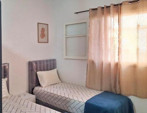 een slaapkamer met een bed en een raam met een bank bij Apartment Comfortable furnished studio in Sale