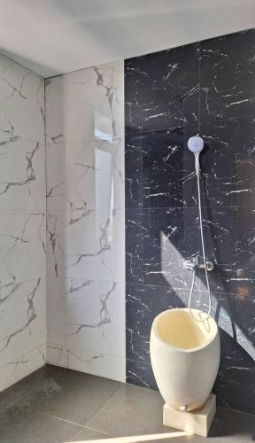 La salle de bains est pourvue de toilettes dans un mur noir et blanc. dans l'établissement Villa Almaria, à Batu