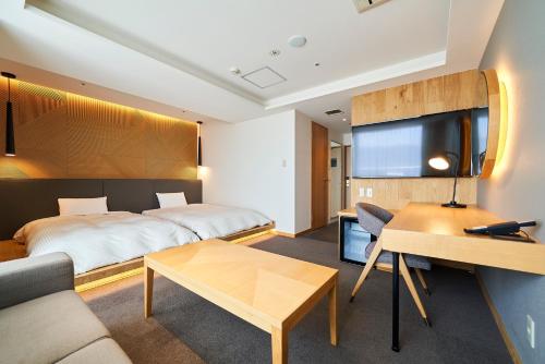 a hotel room with a bed and a table at Hotel Global View Hakodate in Hakodate