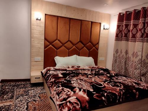 a bedroom with a large bed with a large headboard at Residence Inn Home Stay in Pahalgām