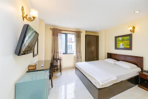 a bedroom with a bed and a flat screen tv at Cát Tường Hotel in Ho Chi Minh City
