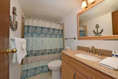Un baño con lavabo, inodoro y espejo. en Maalaea Banyans 203 · MBN 203 OceanFront 1BD Amazing Ocean Views, en Wailuku