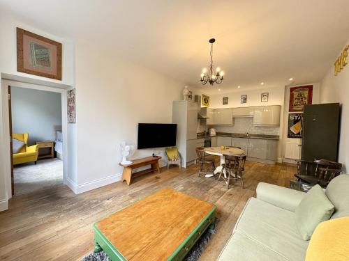 una sala de estar con un sofá y una mesa en Flat 2, Waterloo Apartments, en Radstock
