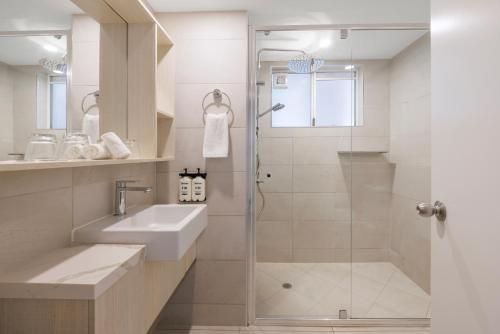 a bathroom with a shower and a sink at Coral Coast Resort Accor Vacation Club Apartments in Palm Cove