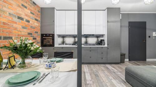a kitchen with a dining table and a brick wall at Maya's Flats & Resorts 24 - Hollywood in Gdańsk