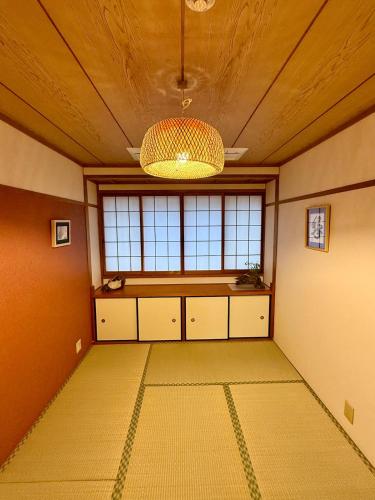 an empty room with a large window and a chandelier at Ume-no-Yado Villa 梅の宿 - A house with a traditional Japanese garden in Osaka