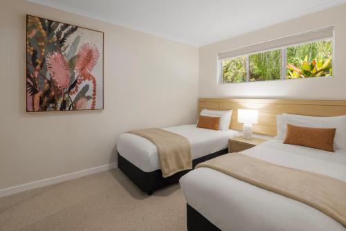 a hotel room with two beds and two windows at Coral Coast Resort Accor Vacation Club Apartments in Palm Cove