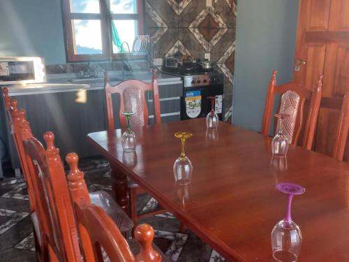a dining room table with chairs and a table with wine glasses on it at Casa de familia in Cachí