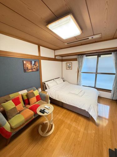 a large bedroom with a bed and a couch at Ume-no-Yado Villa 梅の宿 - A house with a traditional Japanese garden in Osaka