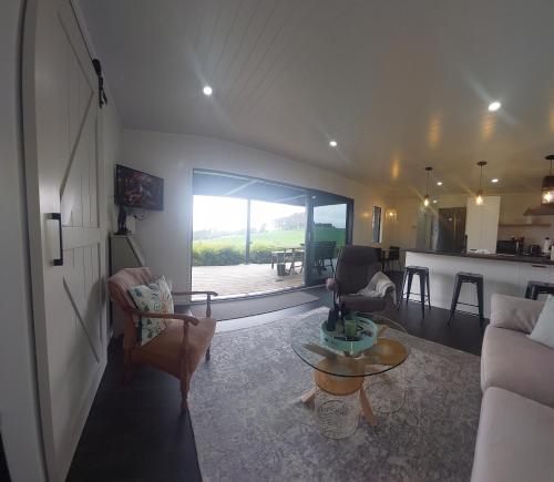 a living room with a couch and a table at Onewhero Country Cabin in Onewhero
