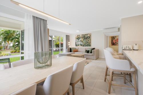 a dining room and living room with a table and chairs at Coral Coast Resort Accor Vacation Club Apartments in Palm Cove