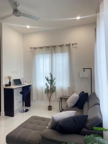 a living room with a couch and a desk at City Abode Kingston Jamaica in Kingston