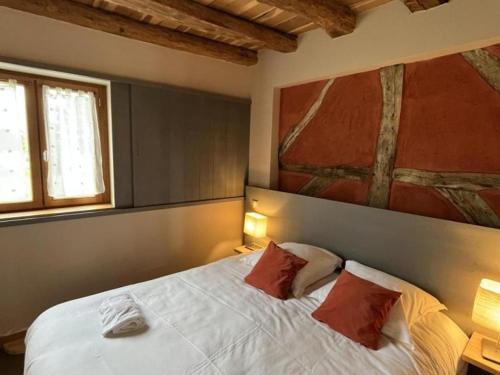 a bedroom with a bed with two pillows and a painting at Gîte La Huzarde: Havre de paix en nature, Allier - FR-1-489-599 in La Faye