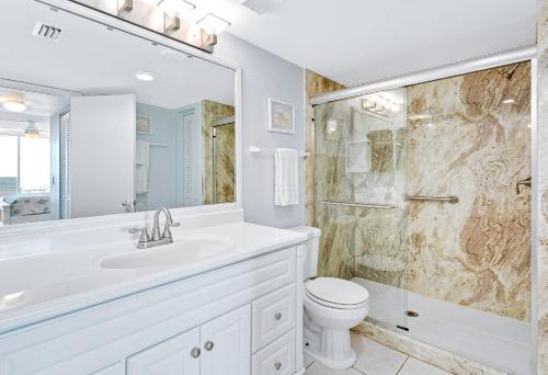 Un baño blanco con ducha y WC. en Indian Harbour Beach Club 303, en Indian Harbour Beach