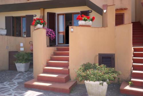 una casa con dos macetas de flores en las escaleras en Appartamento Paola en Marciana Marina