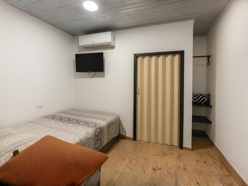 a room with two beds and a sliding door at Hotel MONARCA in Jamundí