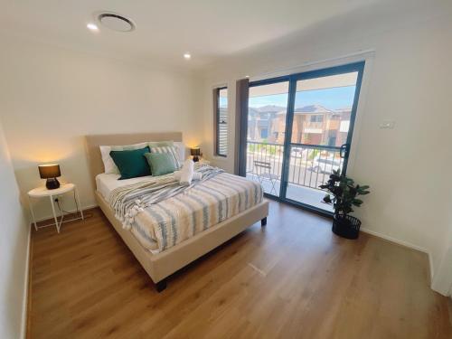 a bedroom with a bed and a large window at Colebee5 BR house near park and shop in Schofields
