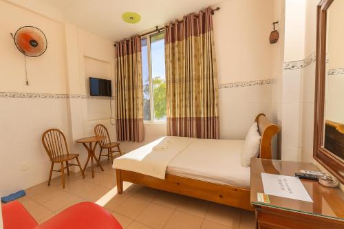 a room with a bed and a desk and chairs at Ly Ly Hotel in Ho Chi Minh City