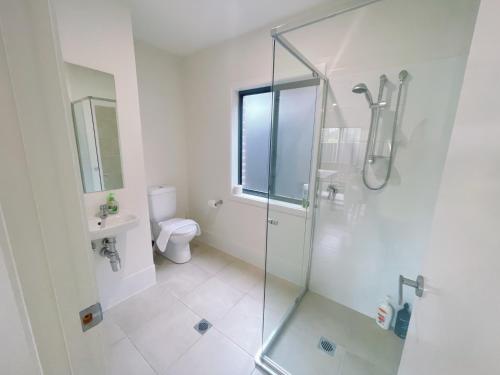 a bathroom with a glass shower and a toilet at Colebee5 BR house near park and shop in Schofields