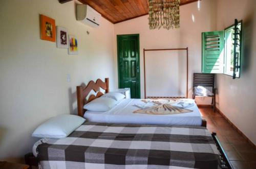 a bedroom with a large bed with a checkered blanket at Pousada Sitio Phoenix in Prea