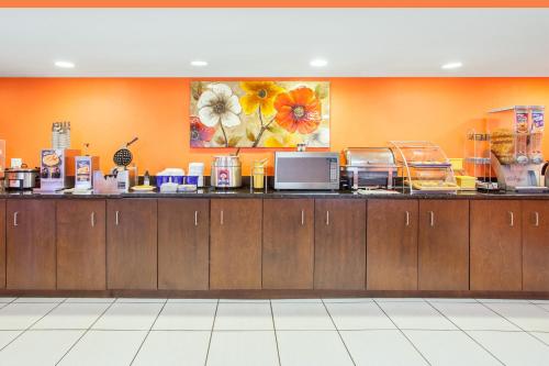 een keuken met oranje muren en aasteryasteryasteryasteryasteryasteryasteryasteryasteryasteryasteryastery bij Days Inn by Wyndham Brooksville in Brooksville