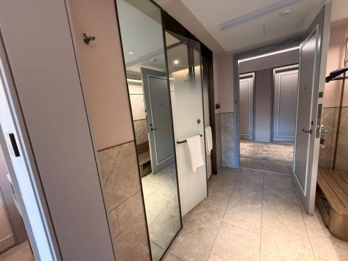 a bathroom with mirrors and a walk in shower at Mercure Nanjing Hongshan in Nanjing