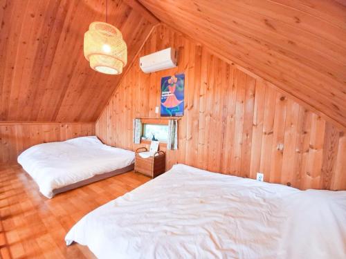 a bedroom with two beds in a wooden room at Hongcheon Riverhill Stay in Torung-gol
