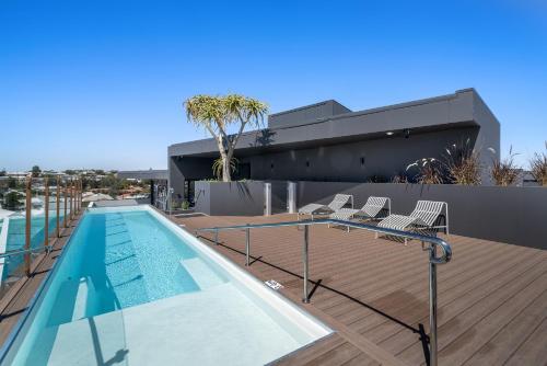 a swimming pool with chairs on the deck of a building at Stylish Studio Near Fremantle Cafés and Beaches in North Fremantle