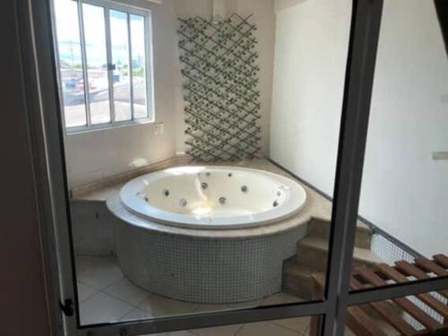 a large tub in a bathroom with a window at Pousada do Bosque in Rio Branco