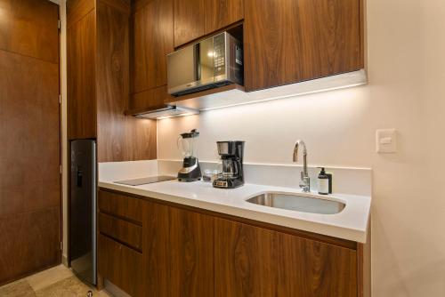 eine Küche mit Spüle und Mikrowelle in der Unterkunft Paravian by Casago in Playa del Carmen