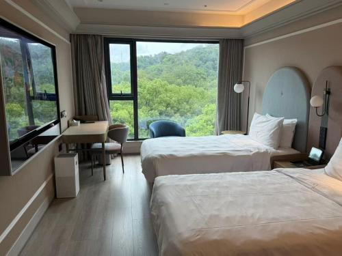 a hotel room with two beds and a desk and a window at Mercure Nanjing Hongshan in Nanjing