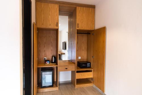 a room with wooden cabinets and a television in a room at Central Residence by Paramount Hospitality in Karachi