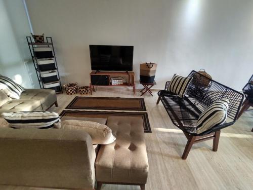 a living room with couches and a flat screen tv at Acacias Residence in Mérida