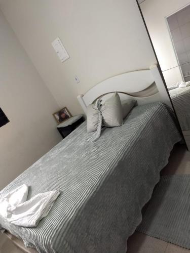 a bedroom with a bed with a white headboard at Pousada Duda Lins in São Vicente