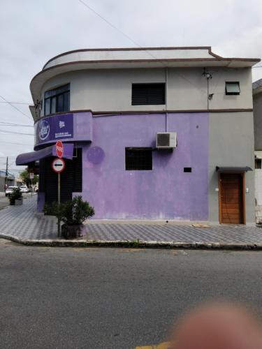 a purple and white building on the side of a street at Pousada Duda Lins in São Vicente