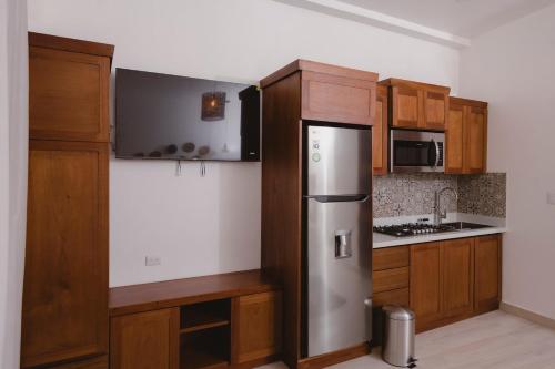 フローレスにあるSanta Delfina 1 Modern and comfortable apartmentのキッチン(木製キャビネット、ステンレス製の冷蔵庫付)