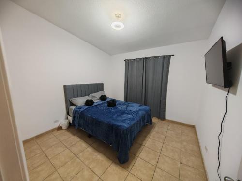 a bedroom with a bed and a television in it at Comfortable 3 bedroom house in Ensenada