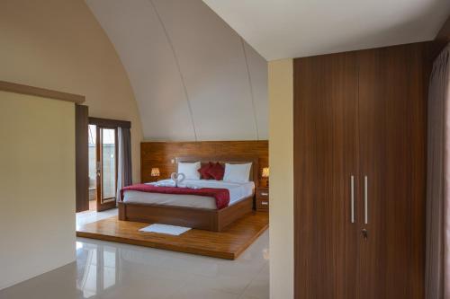 a bedroom with a bed with a wooden headboard at Blue Oceana Villa in Nusa Dua