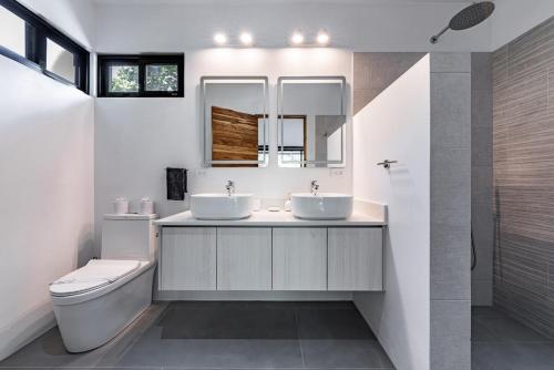 ein Badezimmer mit zwei Waschbecken und einer Toilette in der Unterkunft Luxury villa walking distance to Playa Grande in Refundores