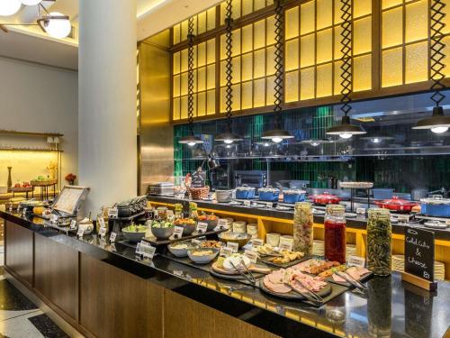 una línea de buffet con platos de comida en un restaurante en Pullman Budapest, en Budapest