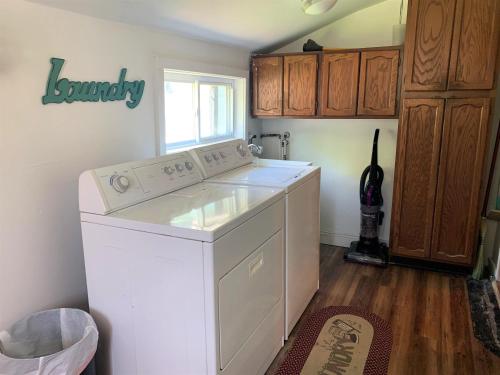 a laundry room with a white washer and a window at The Blue Bliss in Saint Ignace