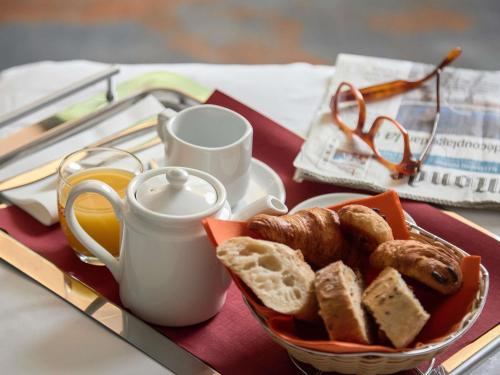 a tray with a plate of bread and a cup of coffee at Mercure Aix-en-Provence La Duranne Gare TGV in Aix-en-Provence