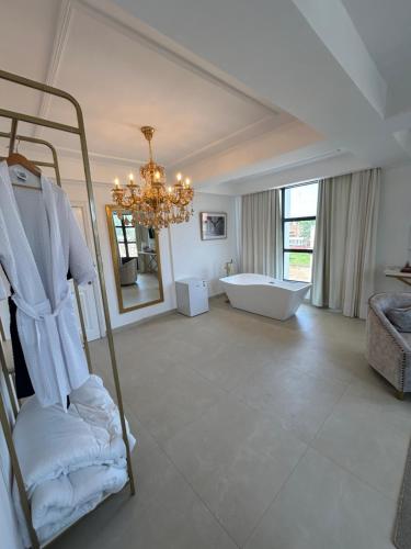 a large bathroom with a chandelier and a bath tub at La Gabbanee Hotel Boutique in Fernando de la Mora
